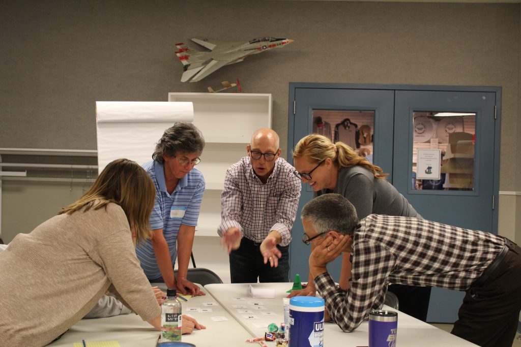 A team of five employees have a lively debate over their organization's communication tactics.