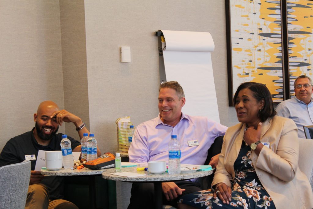A team of three workers laugh over share internal communication failures.