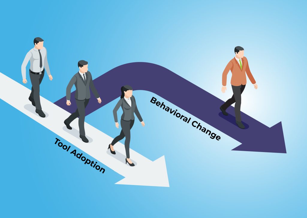 A group of cartoon figures all in black and white head down a path labeled "tool adoption." A single figure in bright colors heads down a different path labeled "behavioral change."
