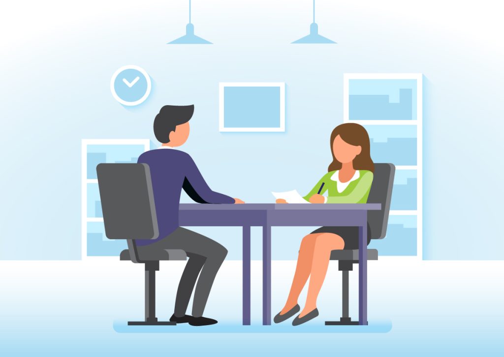 A female facilitator sits at a table to candidly discuss organizational design tactics with an executive.